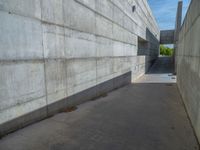 the empty parking lot in front of a wall with apartment buildings on it and a skateboarder on a ramp