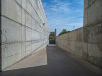 the empty parking lot in front of a wall with apartment buildings on it and a skateboarder on a ramp