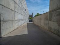 the empty parking lot in front of a wall with apartment buildings on it and a skateboarder on a ramp