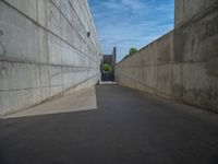 the empty parking lot in front of a wall with apartment buildings on it and a skateboarder on a ramp