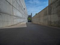 the empty parking lot in front of a wall with apartment buildings on it and a skateboarder on a ramp