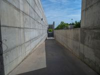 the empty parking lot in front of a wall with apartment buildings on it and a skateboarder on a ramp