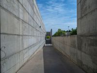 the empty parking lot in front of a wall with apartment buildings on it and a skateboarder on a ramp