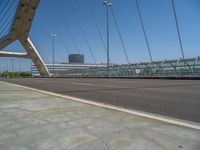 a truck driving across a bridge near a street corner near buildings and a bridge with many cables