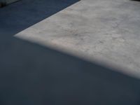 the empty parking lot in front of a wall with apartment buildings on it and a skateboarder on a ramp