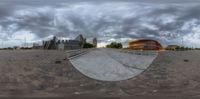 a large circular mirror sitting in the middle of a street on a cloudy day,