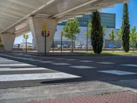 a car sitting at an empty street underneath a overpass overhang that contains a train stop, and cars and a pedestrian