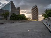 there is a large cement bridge over the road on a cloudy day with tall buildings in the background