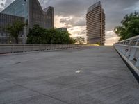 there is a large cement bridge over the road on a cloudy day with tall buildings in the background