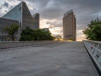 there is a large cement bridge over the road on a cloudy day with tall buildings in the background