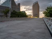 there is a large cement bridge over the road on a cloudy day with tall buildings in the background