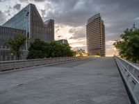 there is a large cement bridge over the road on a cloudy day with tall buildings in the background