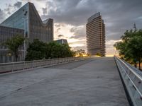 there is a large cement bridge over the road on a cloudy day with tall buildings in the background