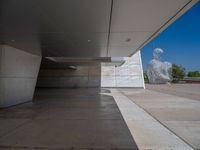 a white building with several steps and large glass panels in the facade is a mosaic that depicts a man