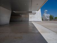 a white building with several steps and large glass panels in the facade is a mosaic that depicts a man