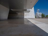 a white building with several steps and large glass panels in the facade is a mosaic that depicts a man