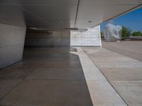 a white building with several steps and large glass panels in the facade is a mosaic that depicts a man