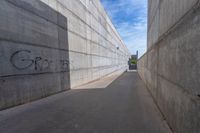 the empty parking lot in front of a wall with apartment buildings on it and a skateboarder on a ramp