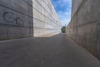 the empty parking lot in front of a wall with apartment buildings on it and a skateboarder on a ramp