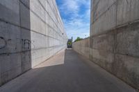 the empty parking lot in front of a wall with apartment buildings on it and a skateboarder on a ramp