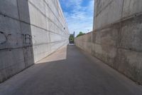 the empty parking lot in front of a wall with apartment buildings on it and a skateboarder on a ramp