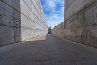 the empty parking lot in front of a wall with apartment buildings on it and a skateboarder on a ramp