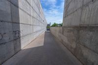 the empty parking lot in front of a wall with apartment buildings on it and a skateboarder on a ramp