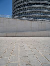 a black fire hydrant is sitting in the concrete area in front of a large building