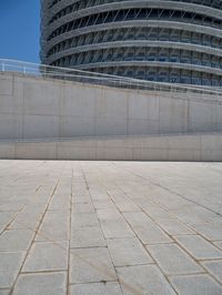 a black fire hydrant is sitting in the concrete area in front of a large building