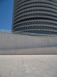 a black fire hydrant is sitting in the concrete area in front of a large building