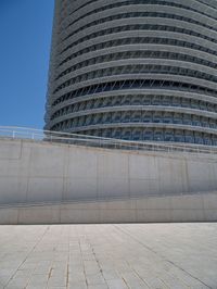 a black fire hydrant is sitting in the concrete area in front of a large building