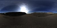 a panorama view of an asphalt road and hills, at the time of a full moon, with an orange fire