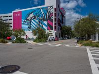 a zebra on the side of a building next to a road with trees and bushes