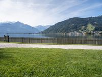 view of lake borro and hills in distance of park area with benches and gated grass