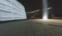 motion blurs the lights from buildings along the sidewalk and bridge in a large city
