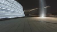 motion blurs the lights from buildings along the sidewalk and bridge in a large city