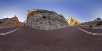 a fish eye lens shot of some rocks and mountains in the desert with a red and white motorcycle