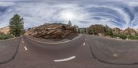 this is a 360 - view photo of an empty road in the middle of rocks