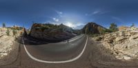 this photo shows a wide angle view of the landscape of a road in the mountains