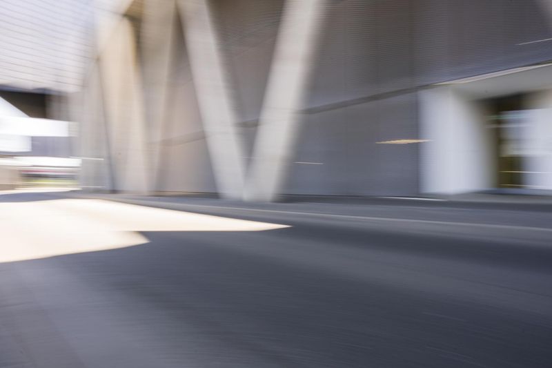 A person on a skateboard rides through a modern architecture city in ...